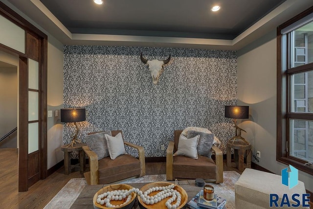 sitting room featuring light hardwood / wood-style floors and a tray ceiling