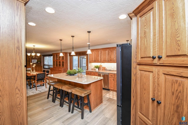 kitchen featuring light hardwood / wood-style floors, a breakfast bar, a center island, and stainless steel appliances