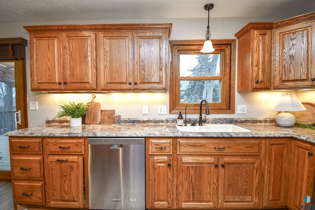 kitchen featuring sink, hanging light fixtures, and stainless steel dishwasher