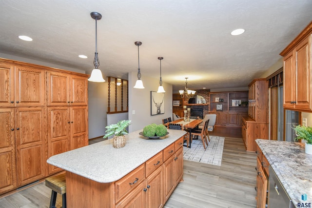 kitchen featuring a kitchen island, hanging light fixtures, light hardwood / wood-style flooring, and a breakfast bar