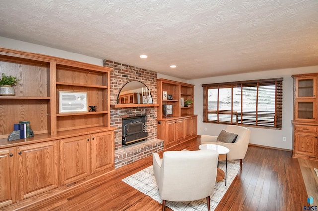 living room featuring hardwood / wood-style floors, a textured ceiling, and a wood stove