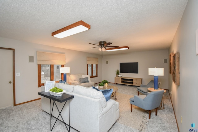 living room with ceiling fan, a textured ceiling, and light carpet