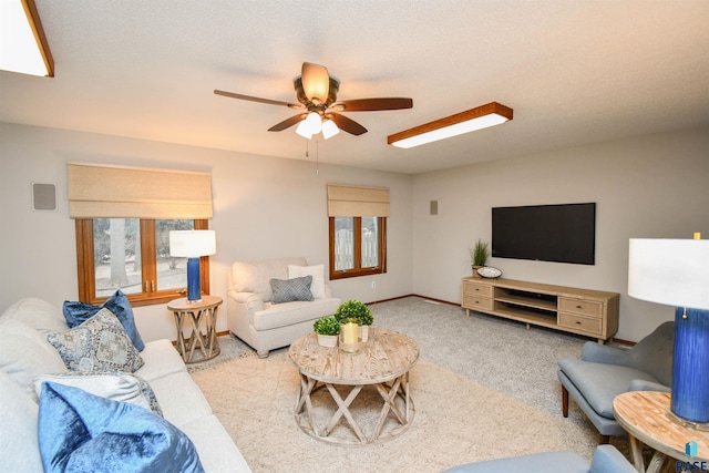 carpeted living room featuring ceiling fan and a textured ceiling