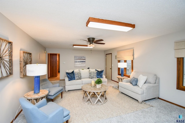 living room with a textured ceiling, carpet floors, and ceiling fan