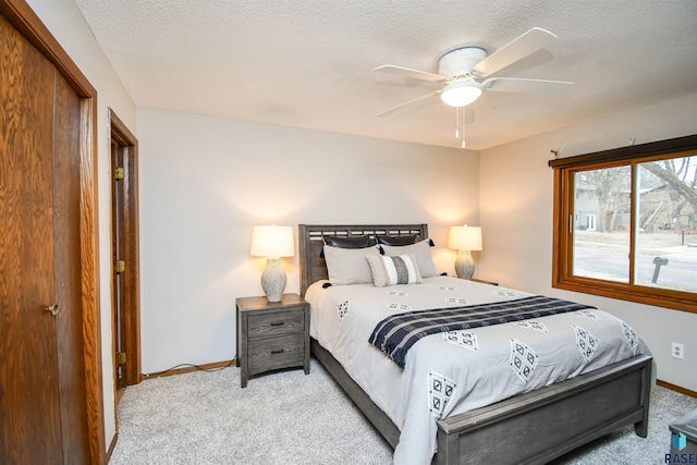 carpeted bedroom featuring ceiling fan and a textured ceiling