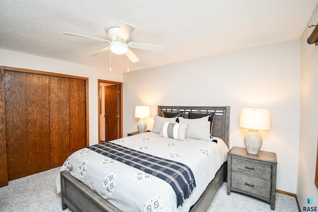 carpeted bedroom with ceiling fan and a textured ceiling