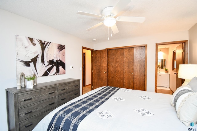 bedroom with a closet, ceiling fan, a textured ceiling, and ensuite bath