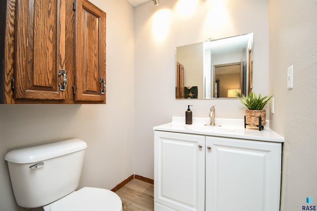 bathroom with hardwood / wood-style floors, toilet, and vanity