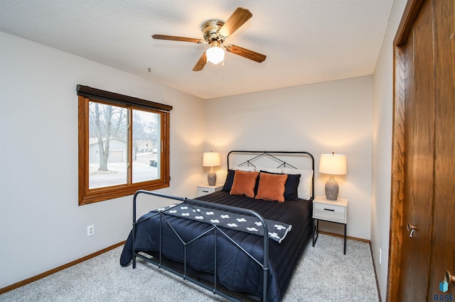 carpeted bedroom featuring a textured ceiling and ceiling fan