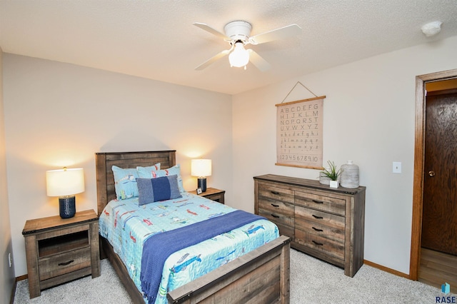 bedroom featuring ceiling fan, a textured ceiling, and light carpet