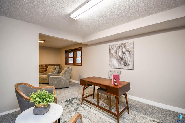 carpeted home office featuring a textured ceiling