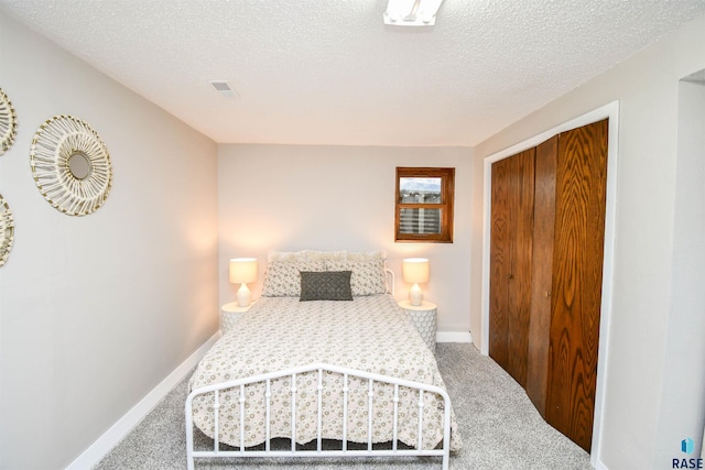 bedroom featuring carpet floors, a textured ceiling, and a closet