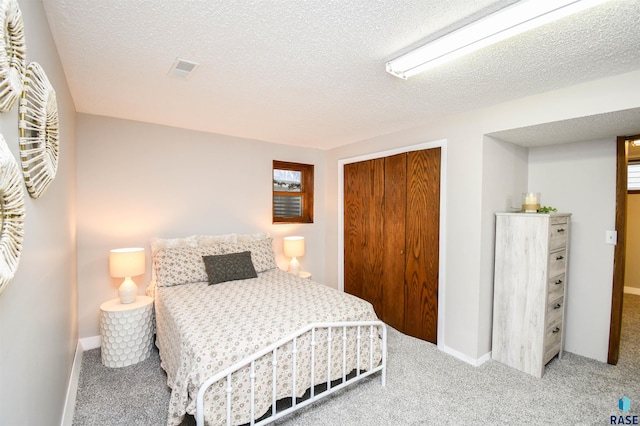 carpeted bedroom featuring a closet and a textured ceiling