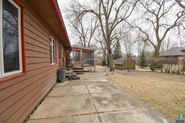 view of side of home with a patio area and a storage shed