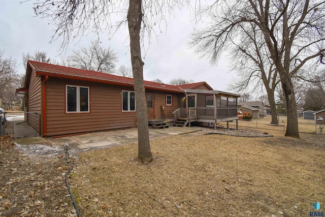 rear view of house with a deck and a sunroom