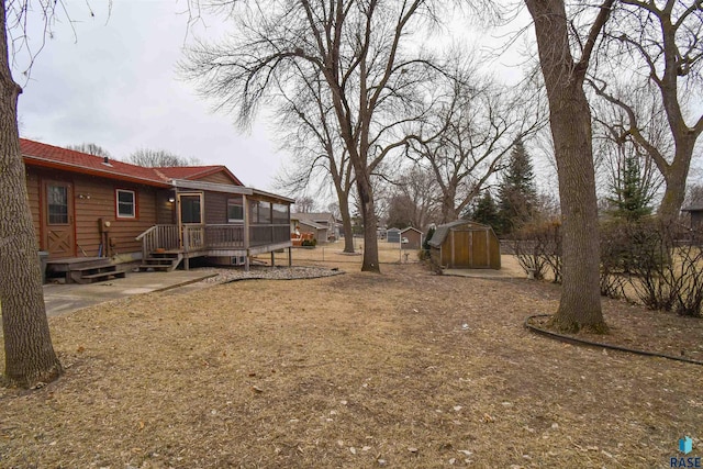 view of yard with a wooden deck and a storage unit