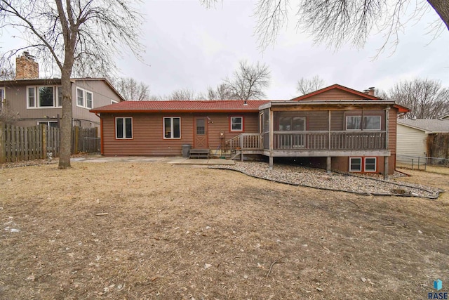 rear view of property with a sunroom and a deck