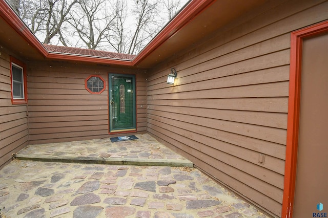 view of exterior entry featuring a patio area