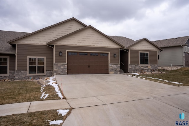 craftsman inspired home featuring a garage and a front lawn