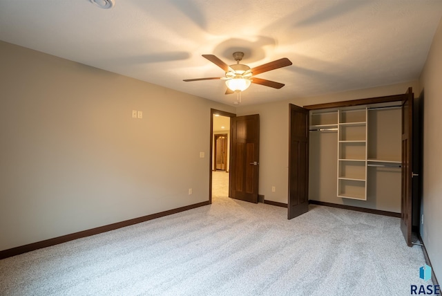 unfurnished bedroom with light colored carpet, a closet, and ceiling fan