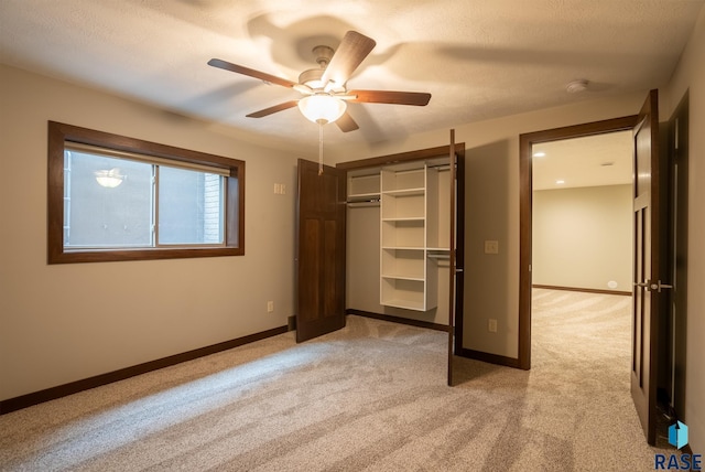 unfurnished bedroom featuring ceiling fan, a closet, and light carpet