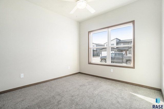 spare room with ceiling fan and carpet