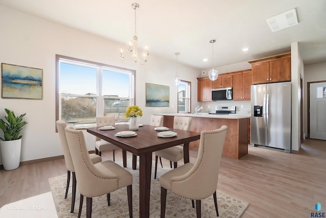 dining room with an inviting chandelier and light hardwood / wood-style floors