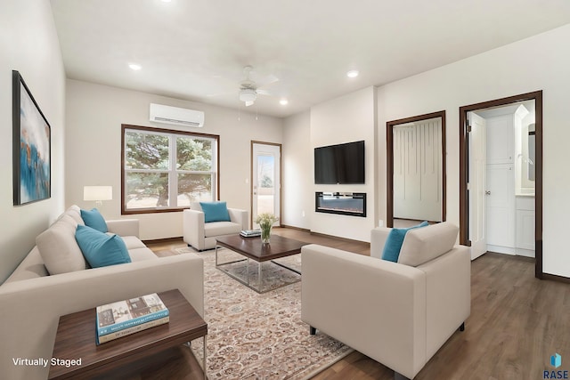 living room with hardwood / wood-style flooring, ceiling fan, and a wall mounted AC