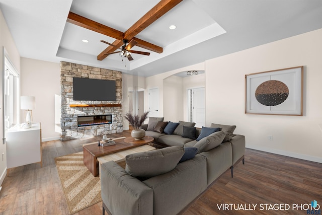 living room featuring ceiling fan, dark wood-type flooring, a fireplace, coffered ceiling, and beamed ceiling