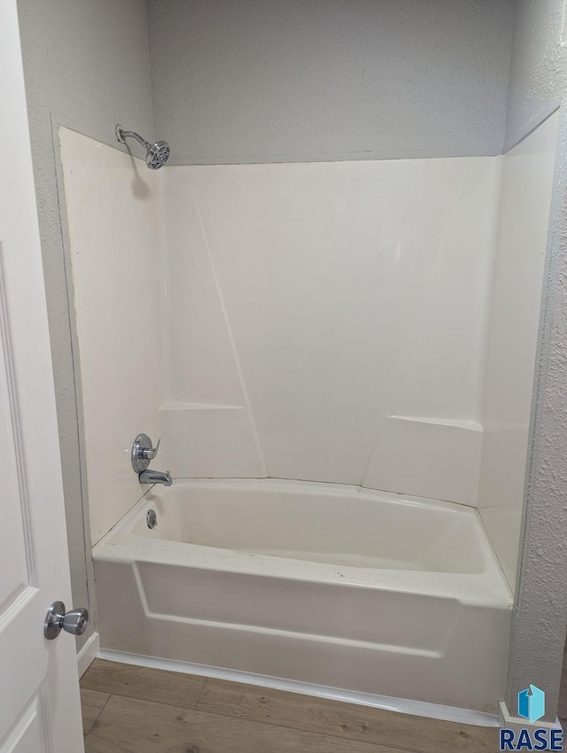 bathroom featuring hardwood / wood-style flooring and  shower combination