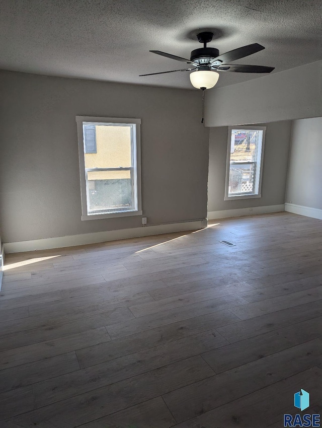 empty room with ceiling fan and light hardwood / wood-style floors