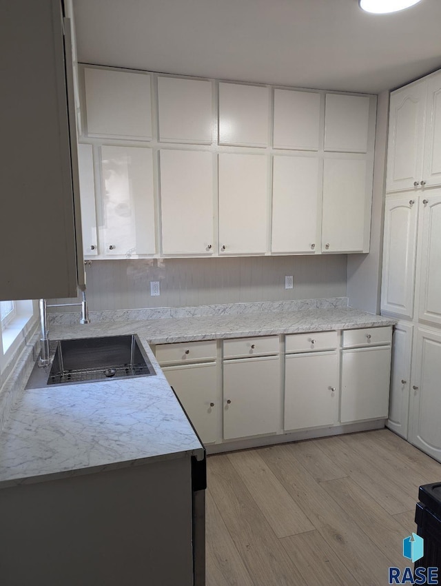 kitchen with white cabinets and light hardwood / wood-style flooring