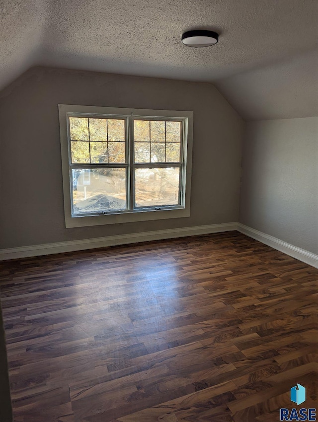 bonus room featuring dark hardwood / wood-style floors, a textured ceiling, and lofted ceiling