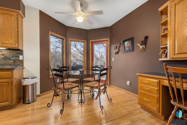 dining room with ceiling fan, a textured ceiling, light hardwood / wood-style flooring, and built in desk