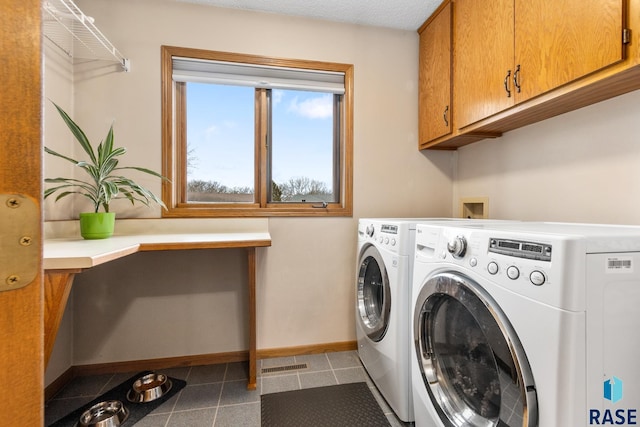 washroom featuring washing machine and dryer and cabinets