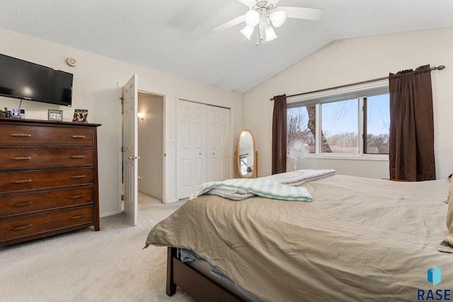 bedroom with a closet, ceiling fan, light carpet, and lofted ceiling