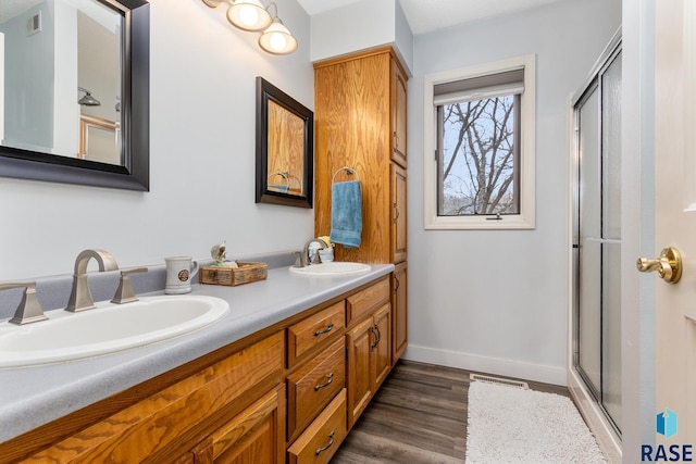 bathroom with vanity, hardwood / wood-style flooring, and an enclosed shower