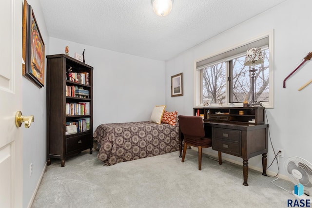 bedroom featuring light carpet and a textured ceiling