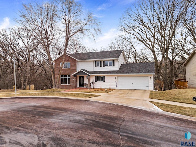 view of property featuring a garage and a front lawn