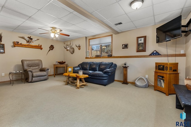 living room featuring a paneled ceiling, carpet floors, and ceiling fan