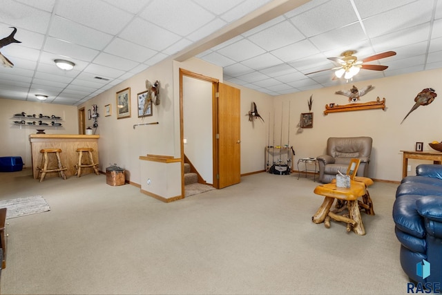 living room with ceiling fan, light colored carpet, a paneled ceiling, and indoor bar