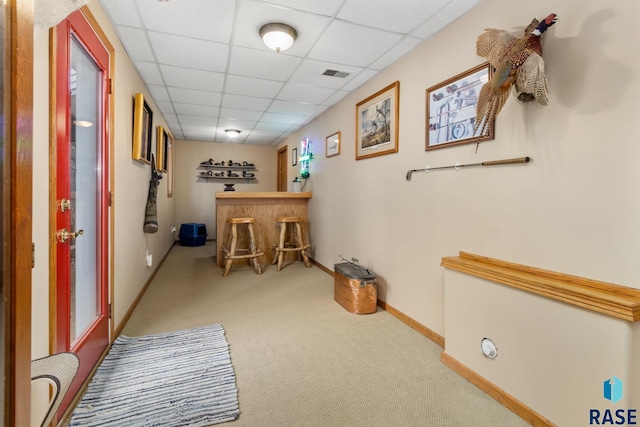 hallway with a drop ceiling and carpet