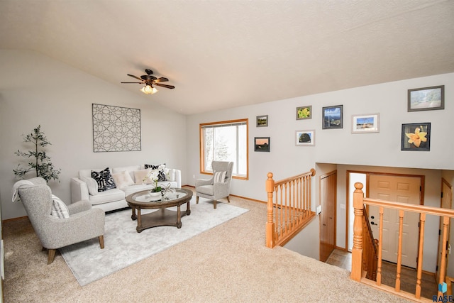 carpeted living room with ceiling fan and lofted ceiling