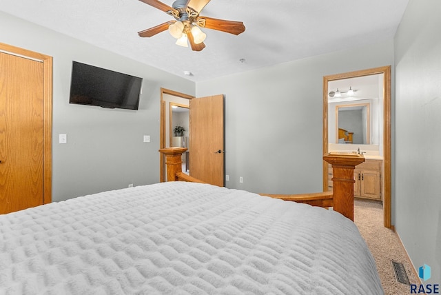 bedroom with ceiling fan, ensuite bathroom, and light carpet