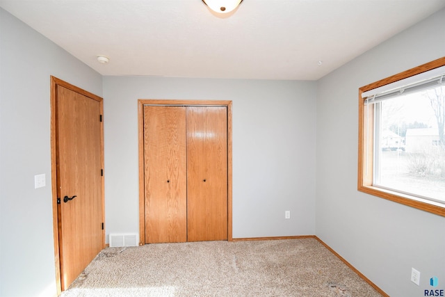 unfurnished bedroom with a closet and light carpet