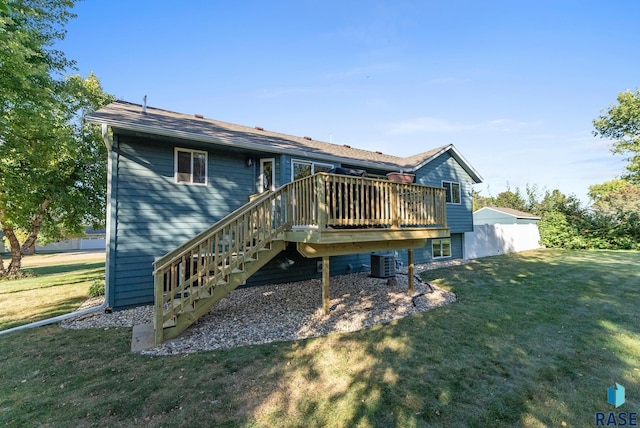 rear view of property with a deck, a yard, and central AC