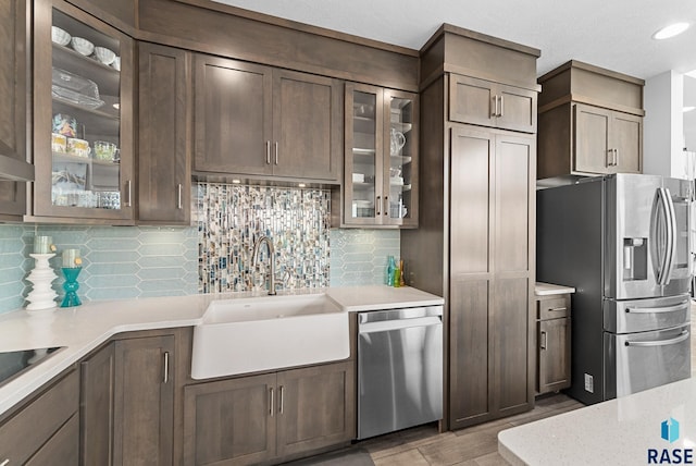 kitchen with sink, dark brown cabinetry, stainless steel appliances, and tasteful backsplash