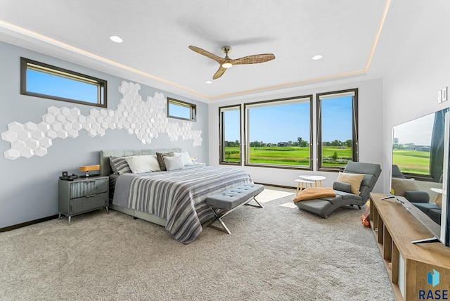 bedroom featuring carpet flooring, a tray ceiling, and ceiling fan