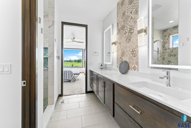 bathroom featuring vanity, a wealth of natural light, tiled shower, and tile patterned floors