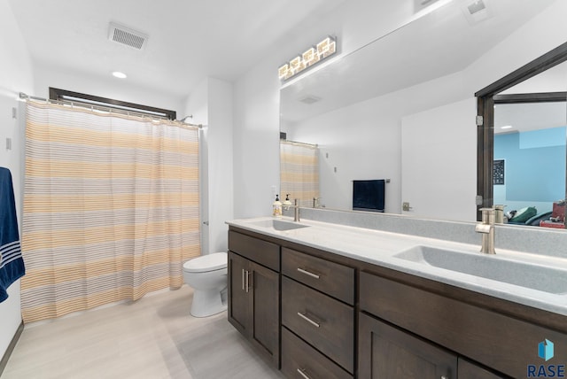 bathroom featuring toilet, vanity, and a shower with curtain